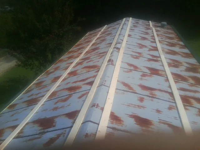Rusted metal roof panels with new wood purlins before replacement — Storm Damage Roof Repair in New Springfield by Roofing Brothers