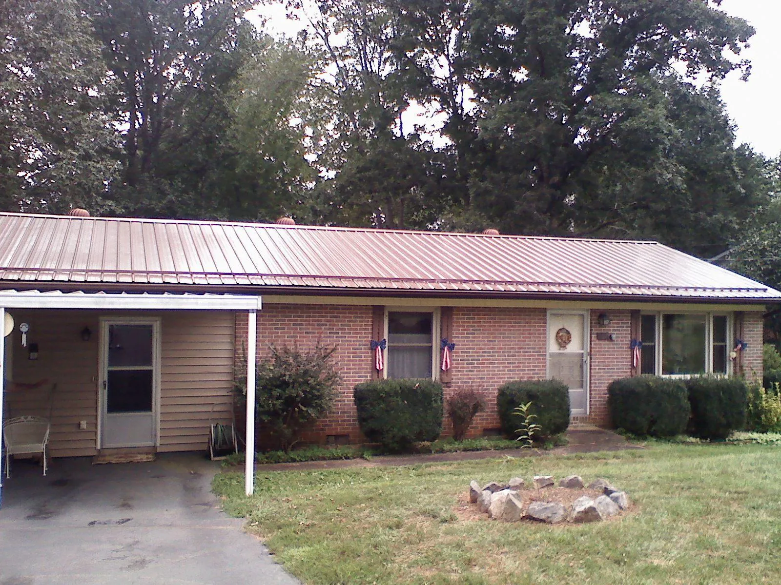 Bronze metal roof and carport on a brick ranch home — Roof Repair work by our crew in New Springfield