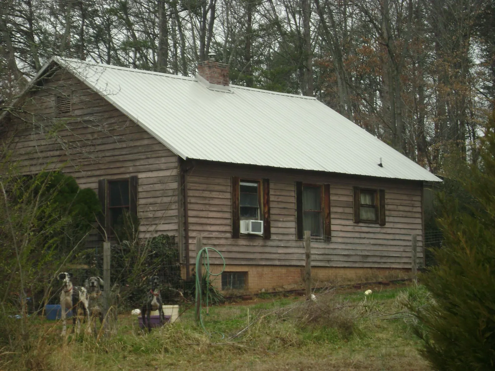 White metal roof on an old wood sided farmhouse, from a Metal Roof Installation job in New Springfield